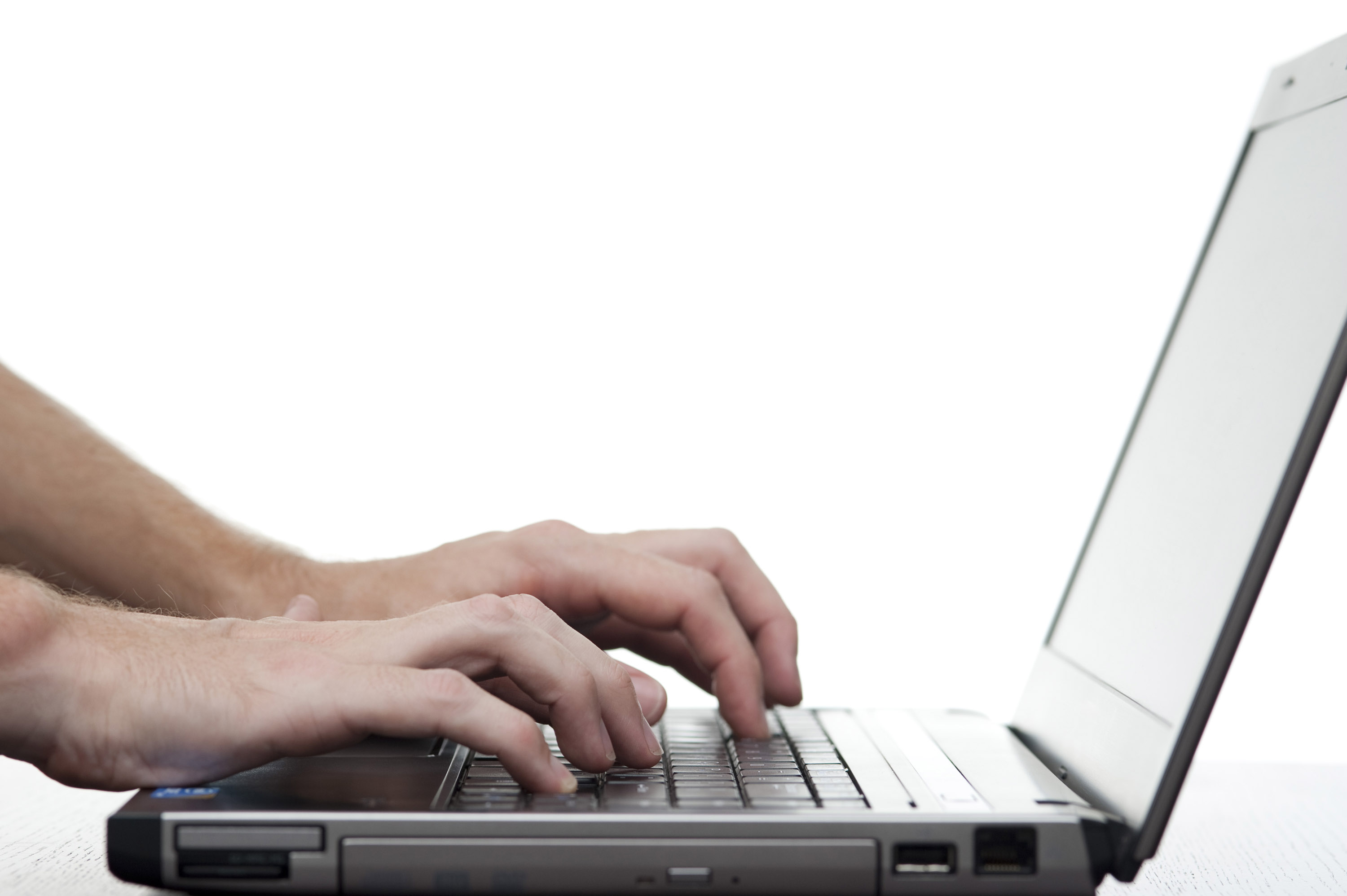 hands typing on a laptop keyboard with lots of copy space on a white background